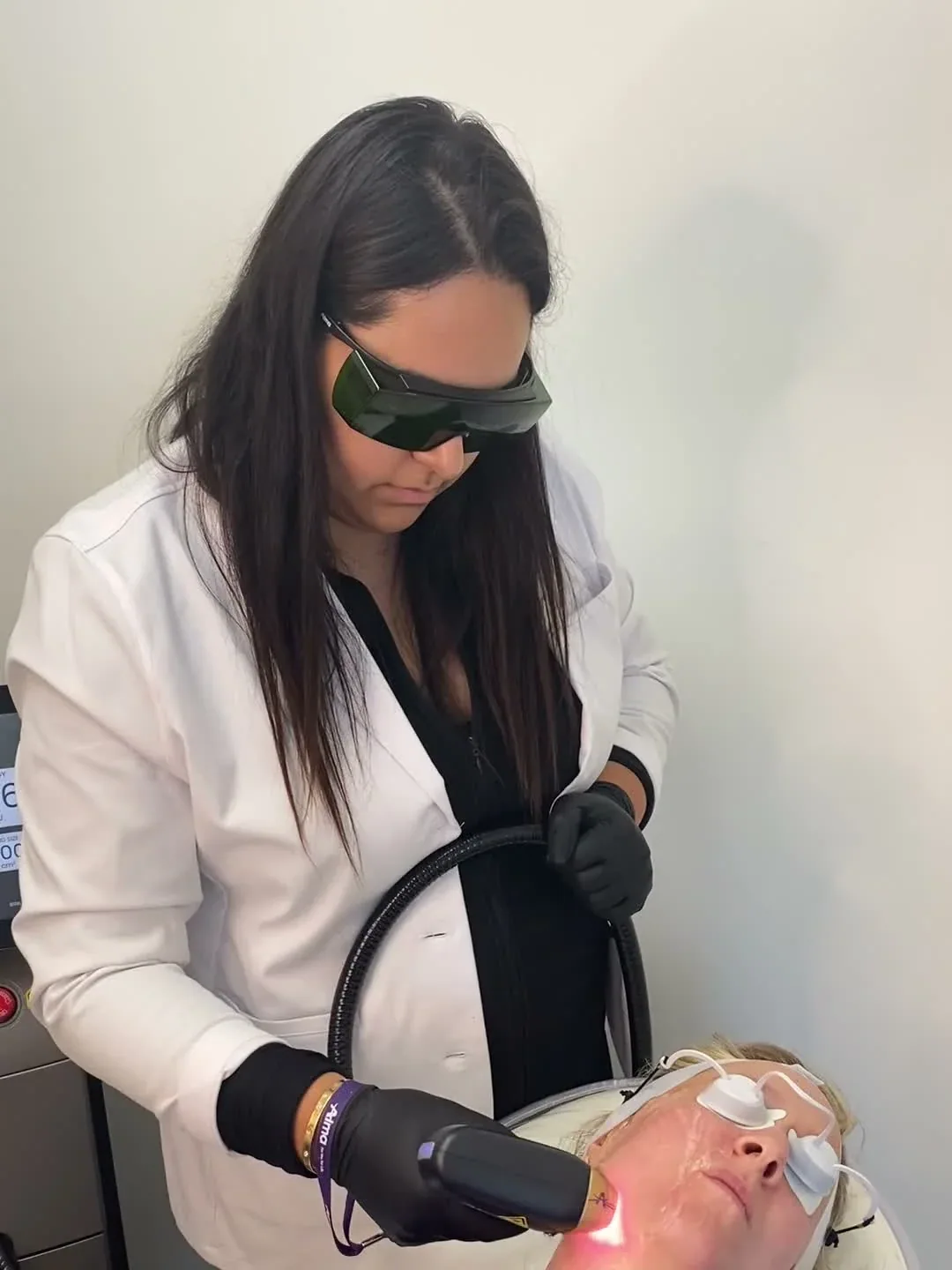 Provider applying a handpiece to a client’s cheek during a Titanium Lift treatment